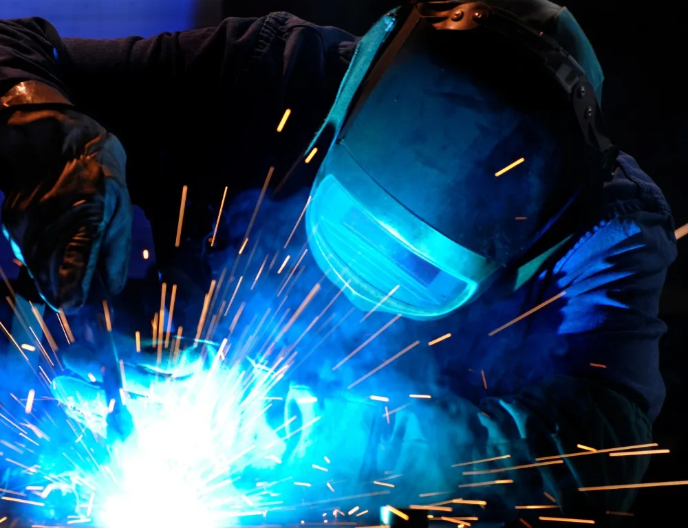 An engineer welding in a protective face mask.