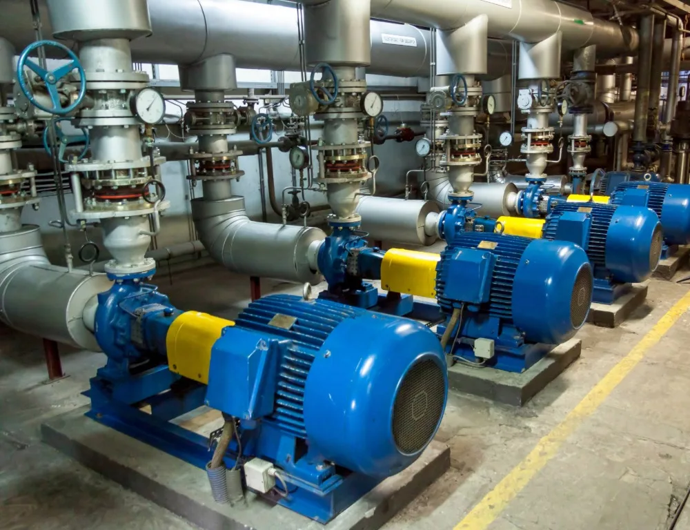 An industrial plantroom full of blue pumps.